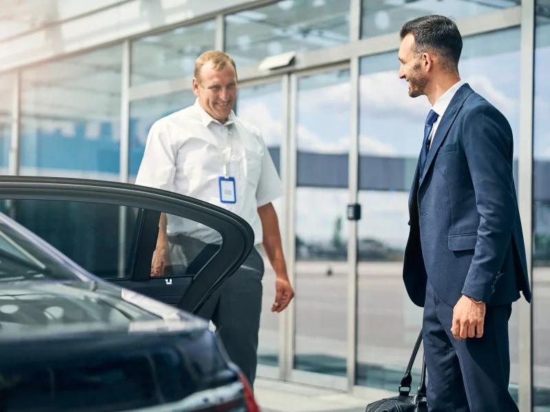cheerful-driver-meeting-friendly-businessman-at-th-2021-09-03-21-02-32-utc Airport Chauffeur
